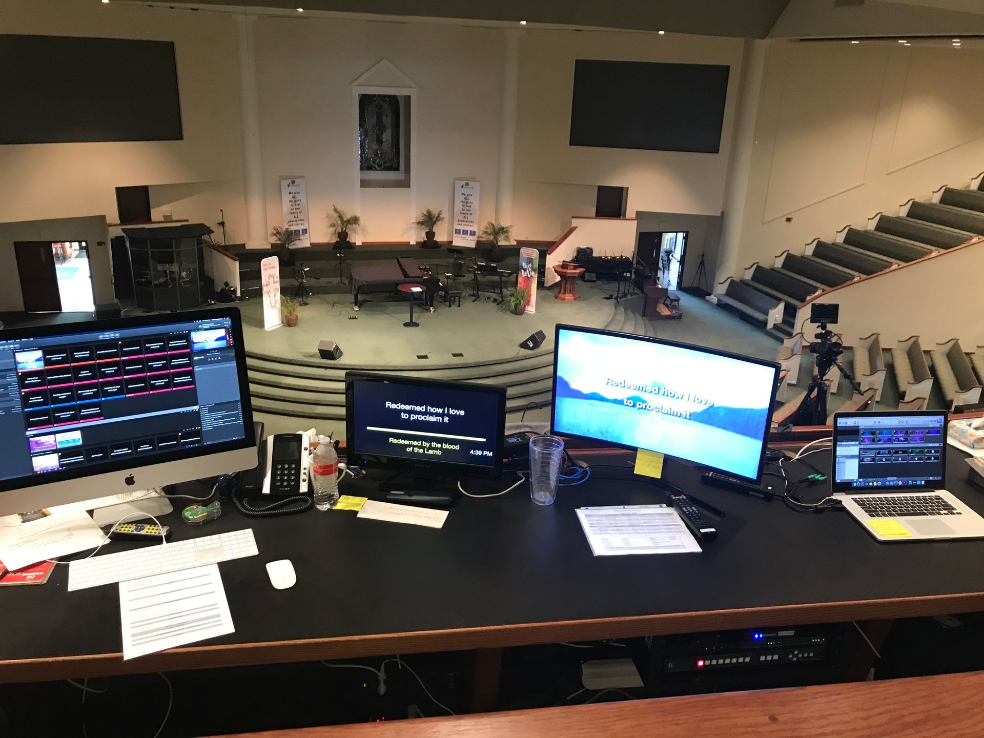 A desk with two computer monitors and a laptop on it