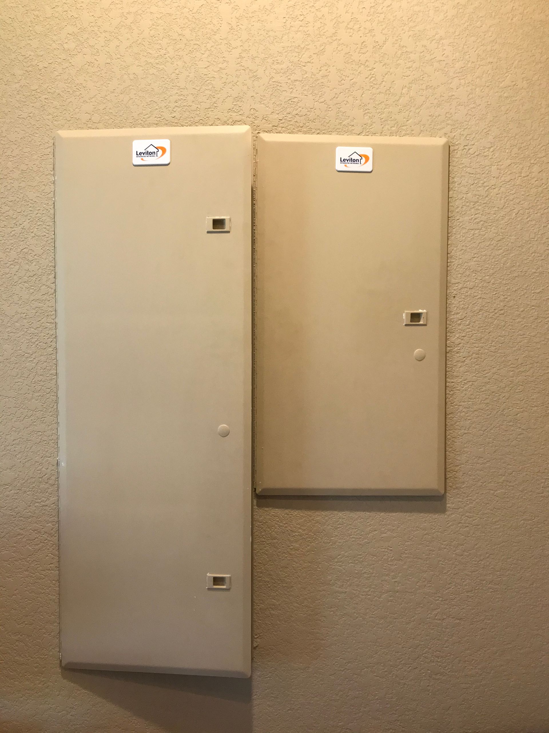 Two white boxes are sitting next to each other on a wall.