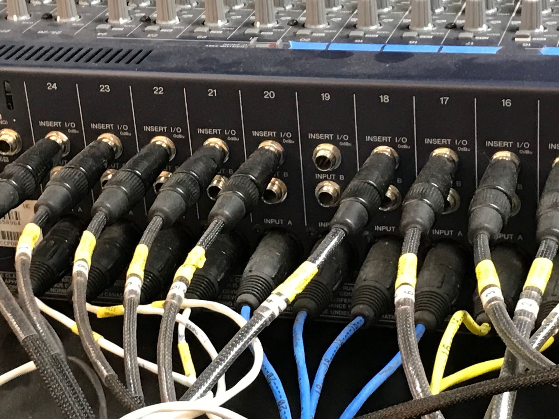 A bunch of cables are plugged into a mixer