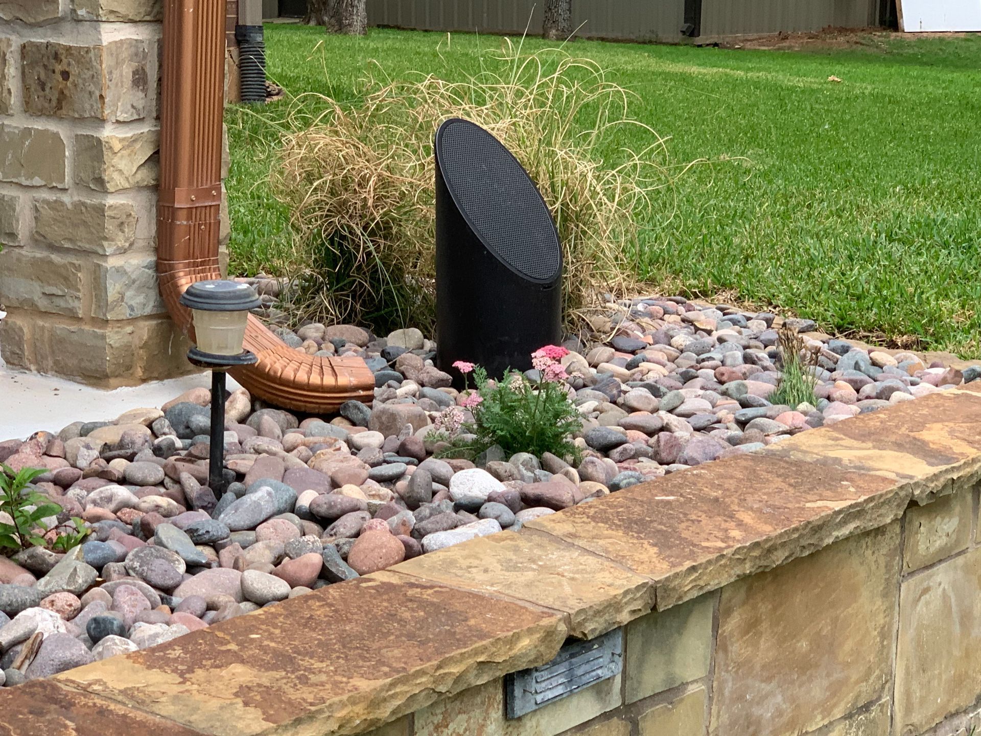 A rock garden with a speaker in the middle of it
