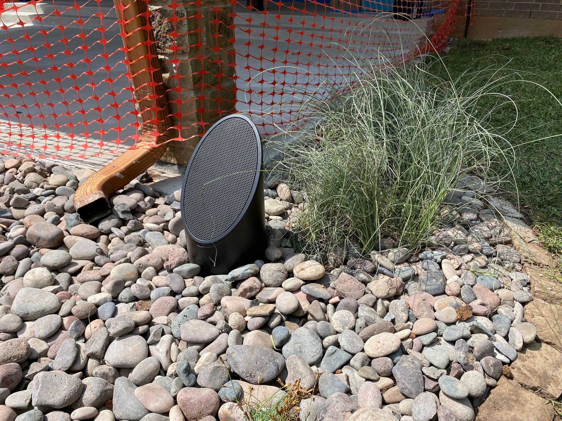 A speaker is sitting on top of a pile of rocks.