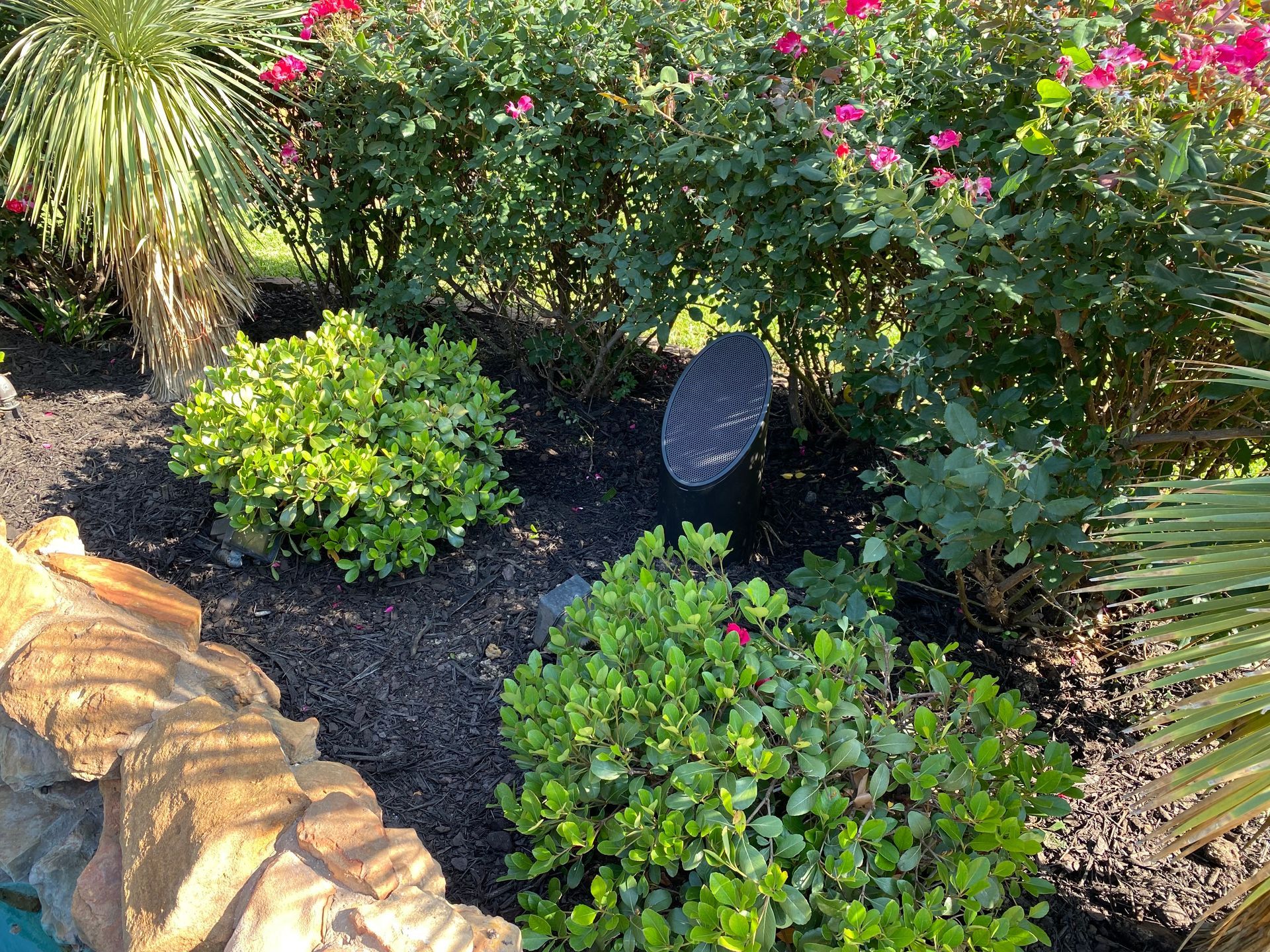 There is a speaker in the middle of the garden.