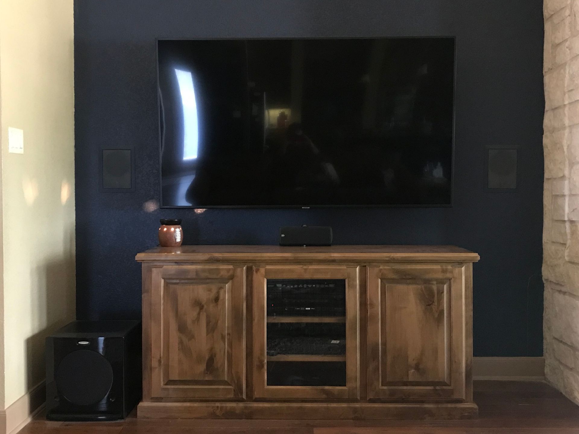 A large flat screen tv is mounted on a wall above a wooden entertainment center