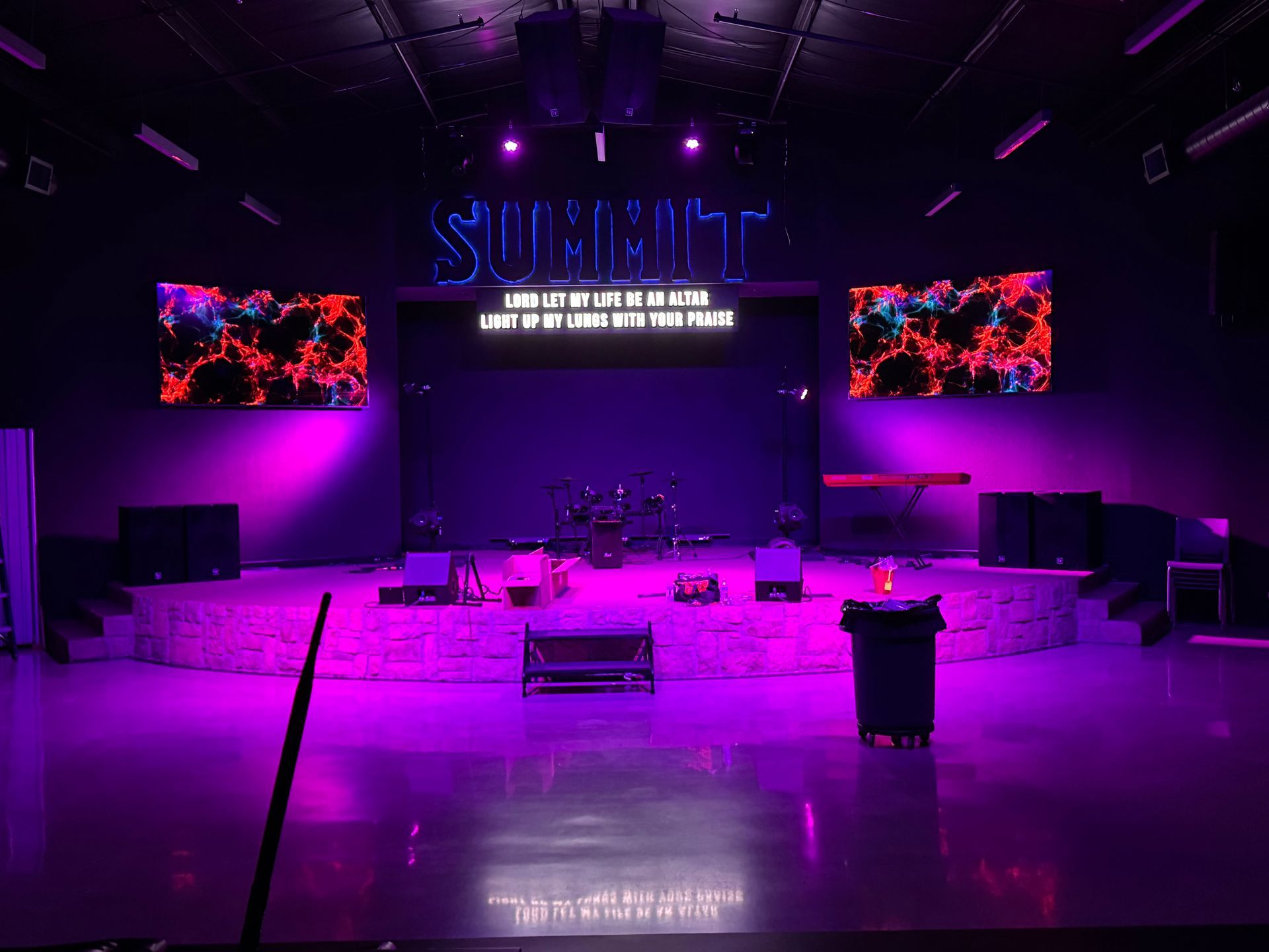 A stage with purple lights and the word summit on it