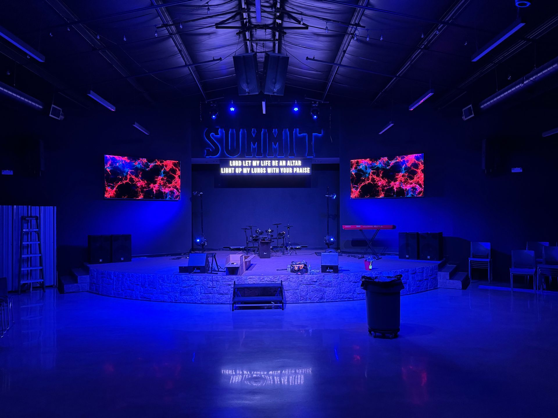 There is a stage in the middle of the room with blue lights.