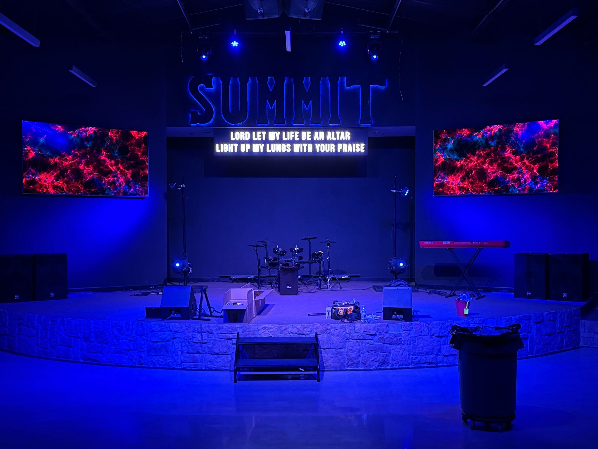 An empty stage with blue lights and a sign that says summit.