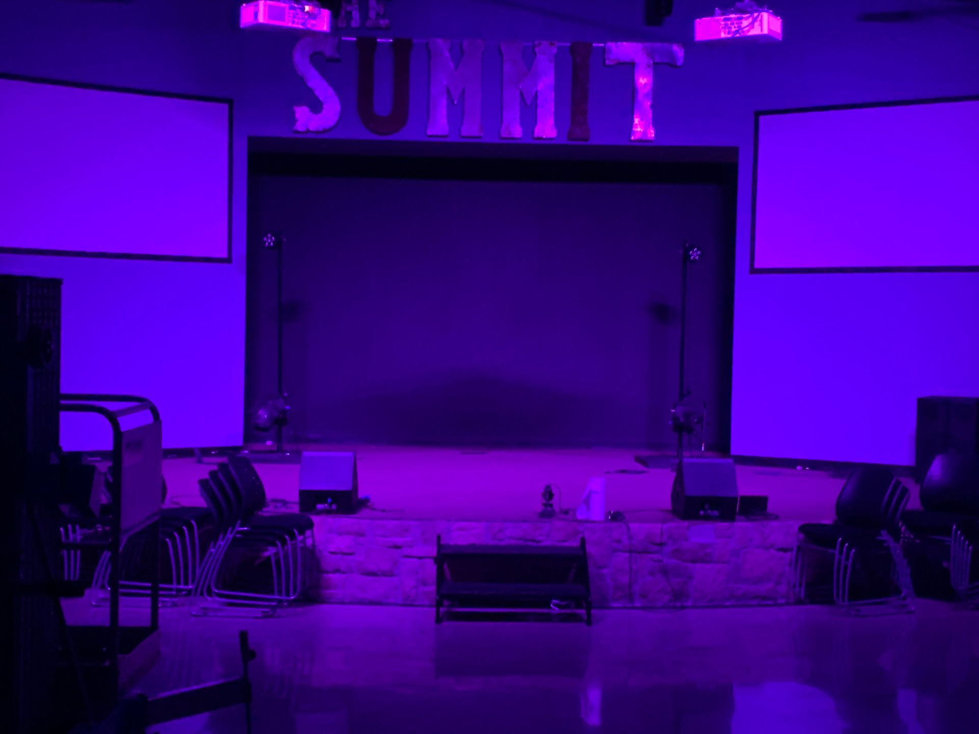 A stage with purple lights and the word summit on it.