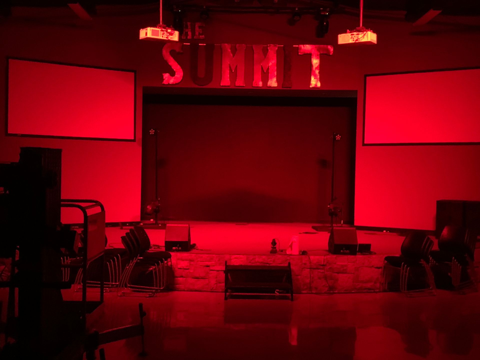 A stage with red lights and a sign that says `` the summit ''.