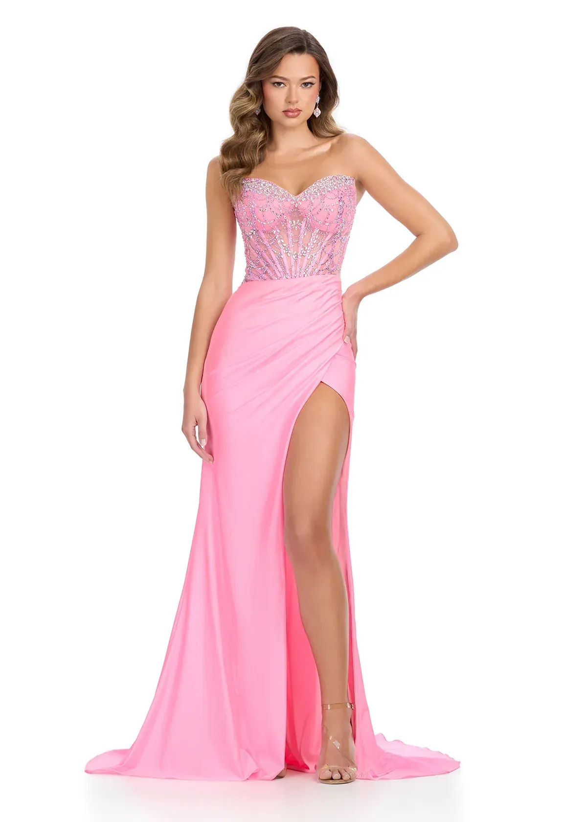 A woman is wearing a pink dress with a high slit.