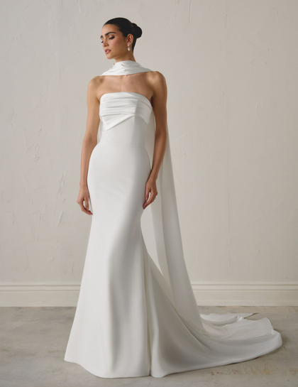 A man in a suit and tie is adjusting his jacket.