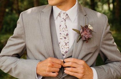 A man in a suit and tie is adjusting his jacket.