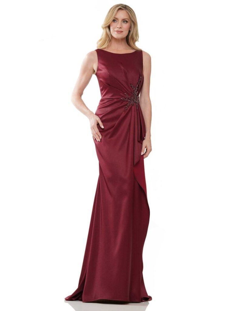 A woman is wearing a burgundy dress with a rhinestone waistband.