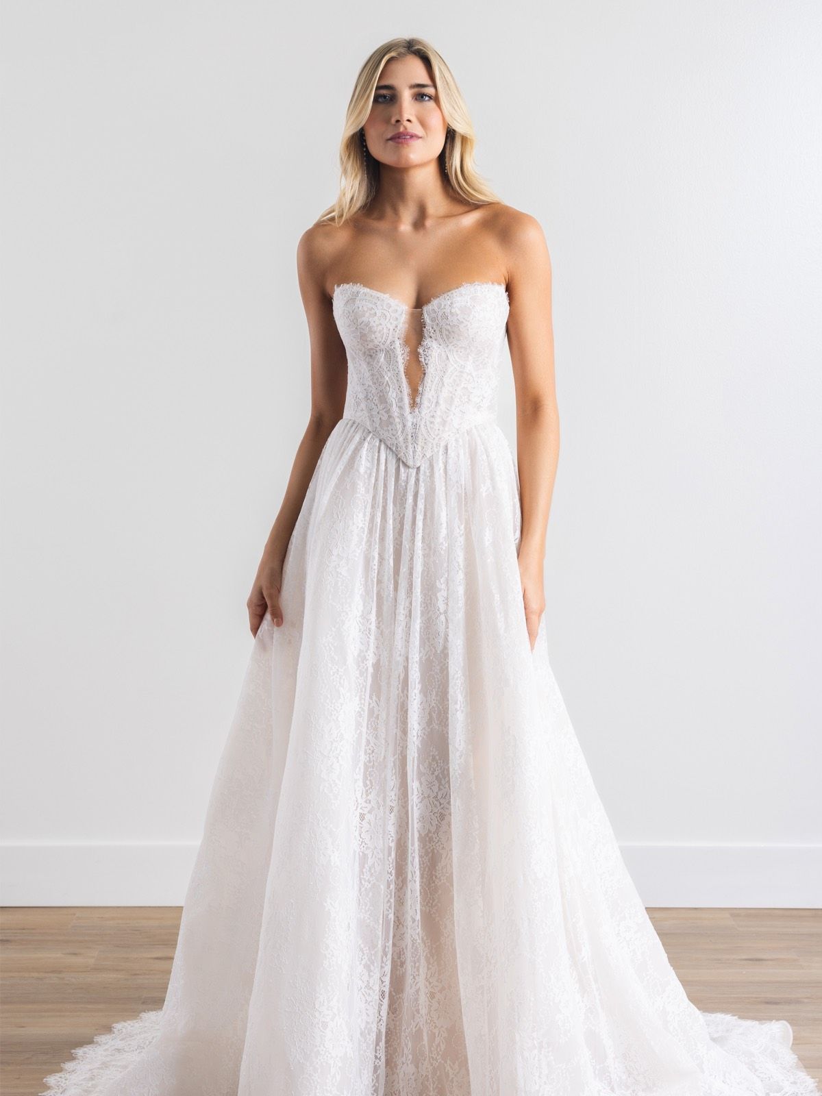 A woman in a wedding dress and veil is standing in front of a door.