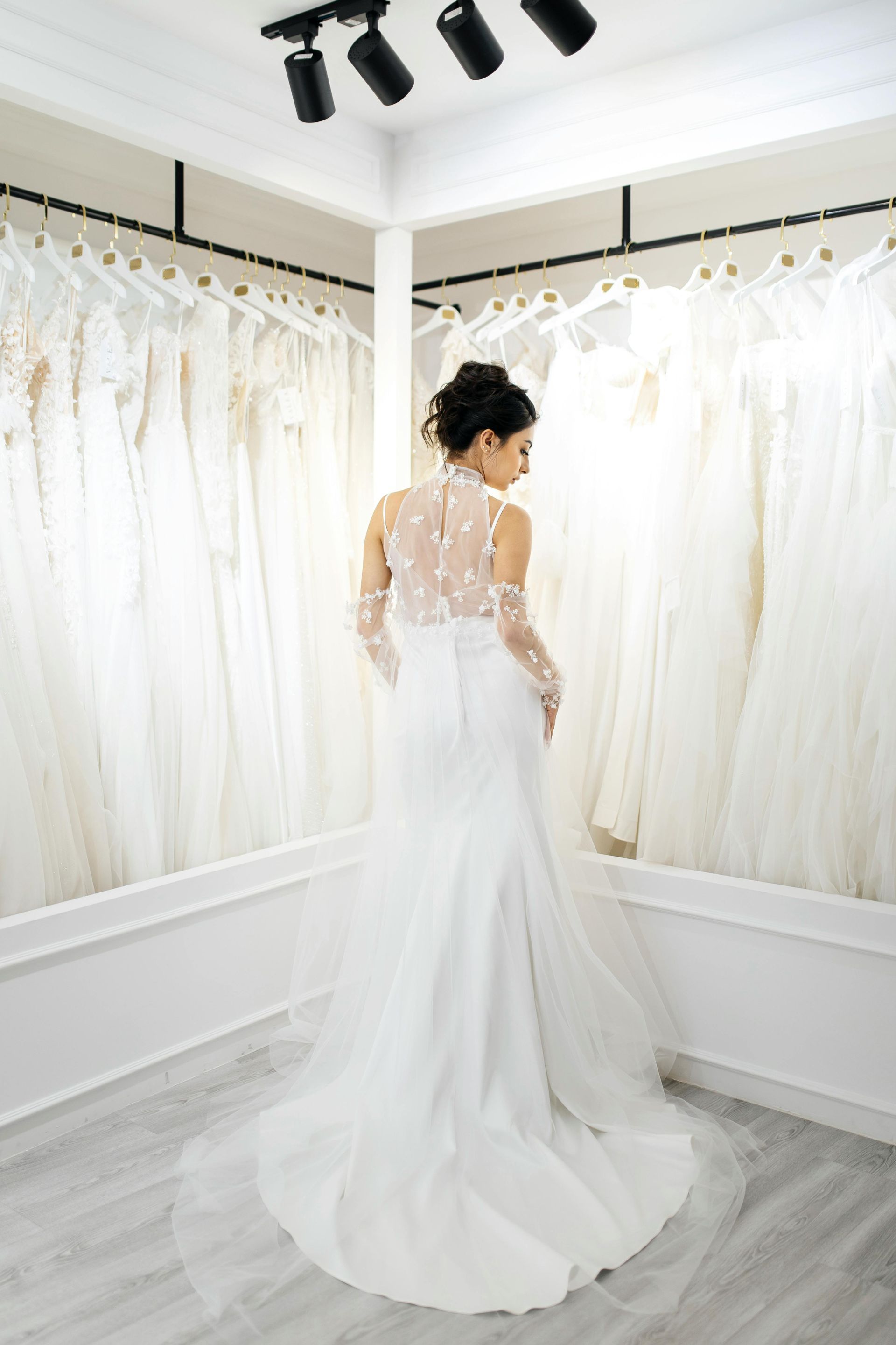 A woman in a white wedding dress is standing in a room.