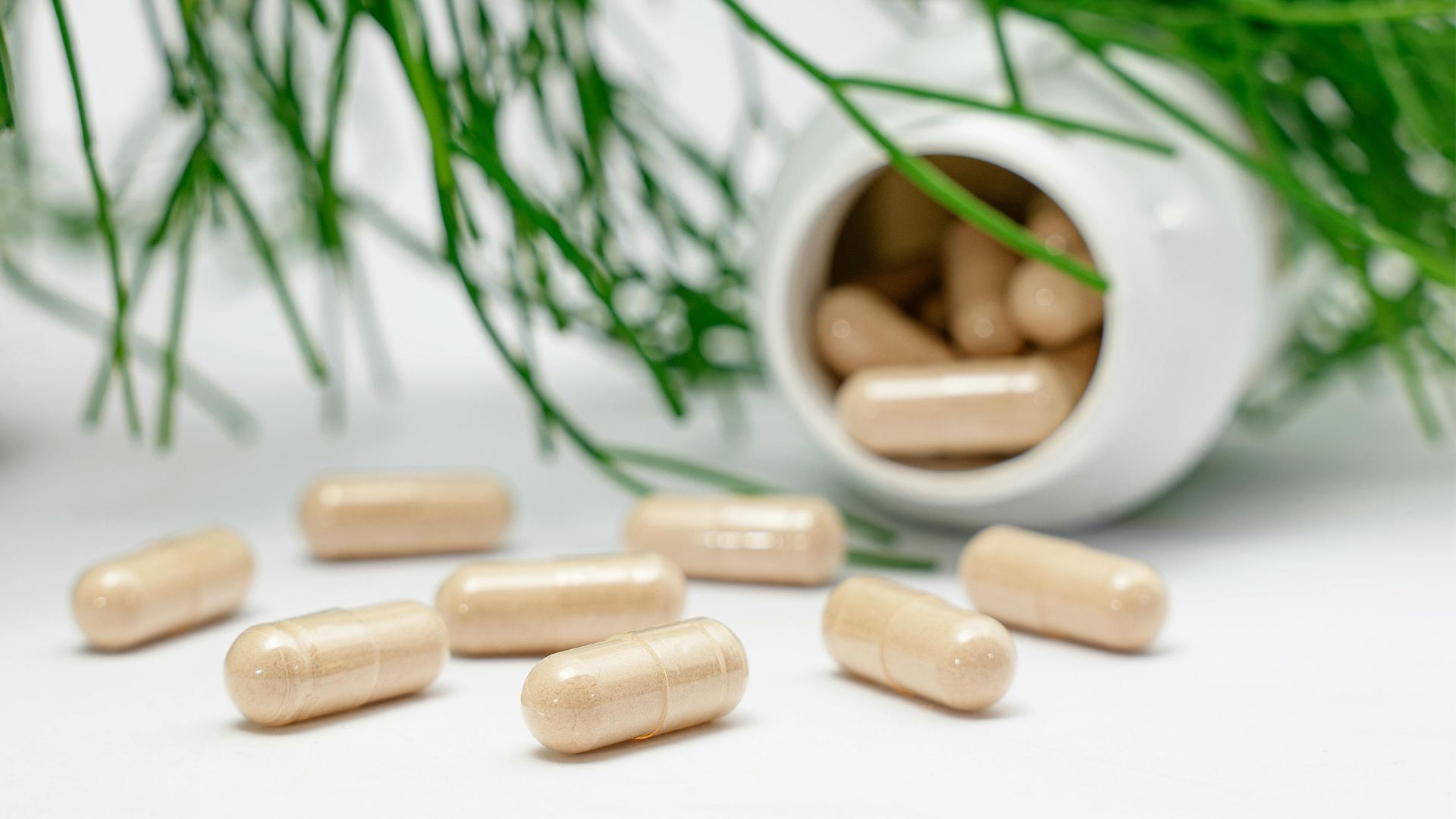 A bottle of pills is spilling out of it on a table.