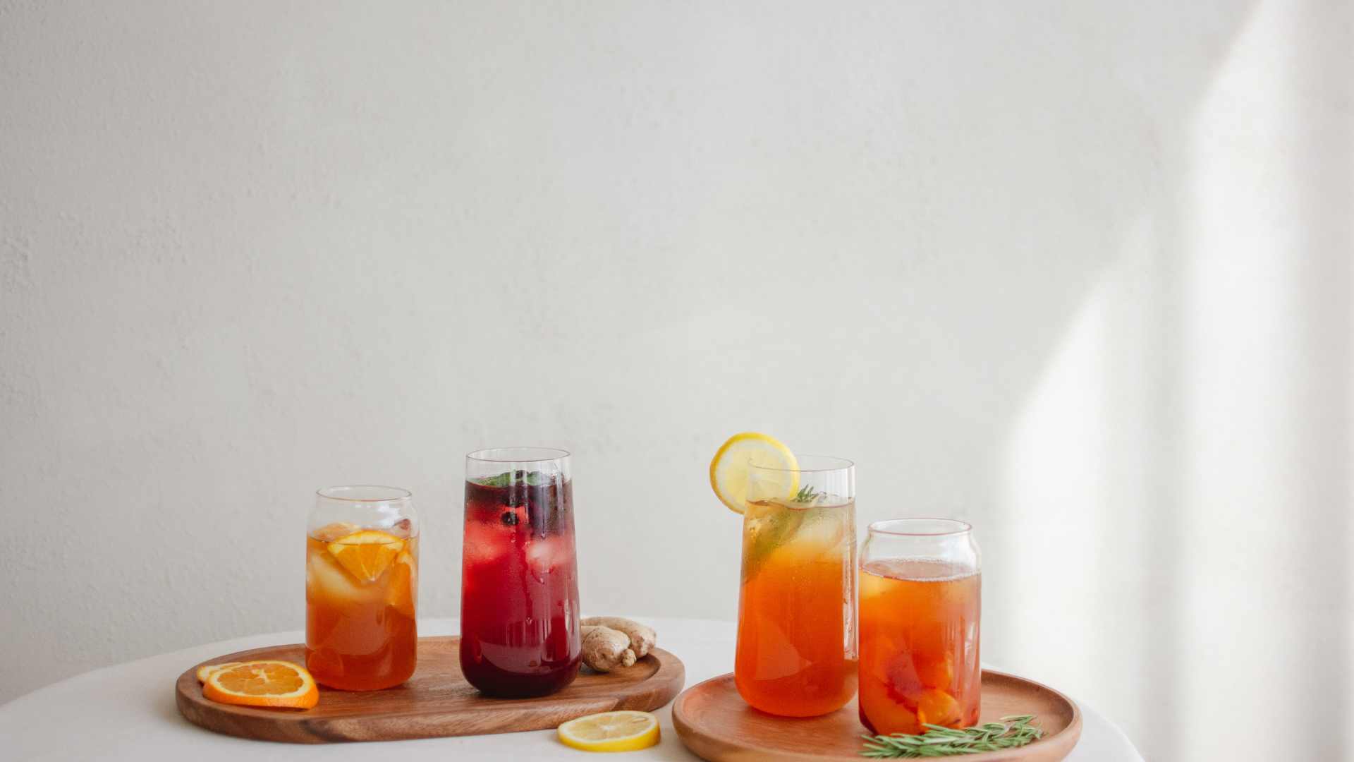 A table topped with four glasses of different types of drinks.