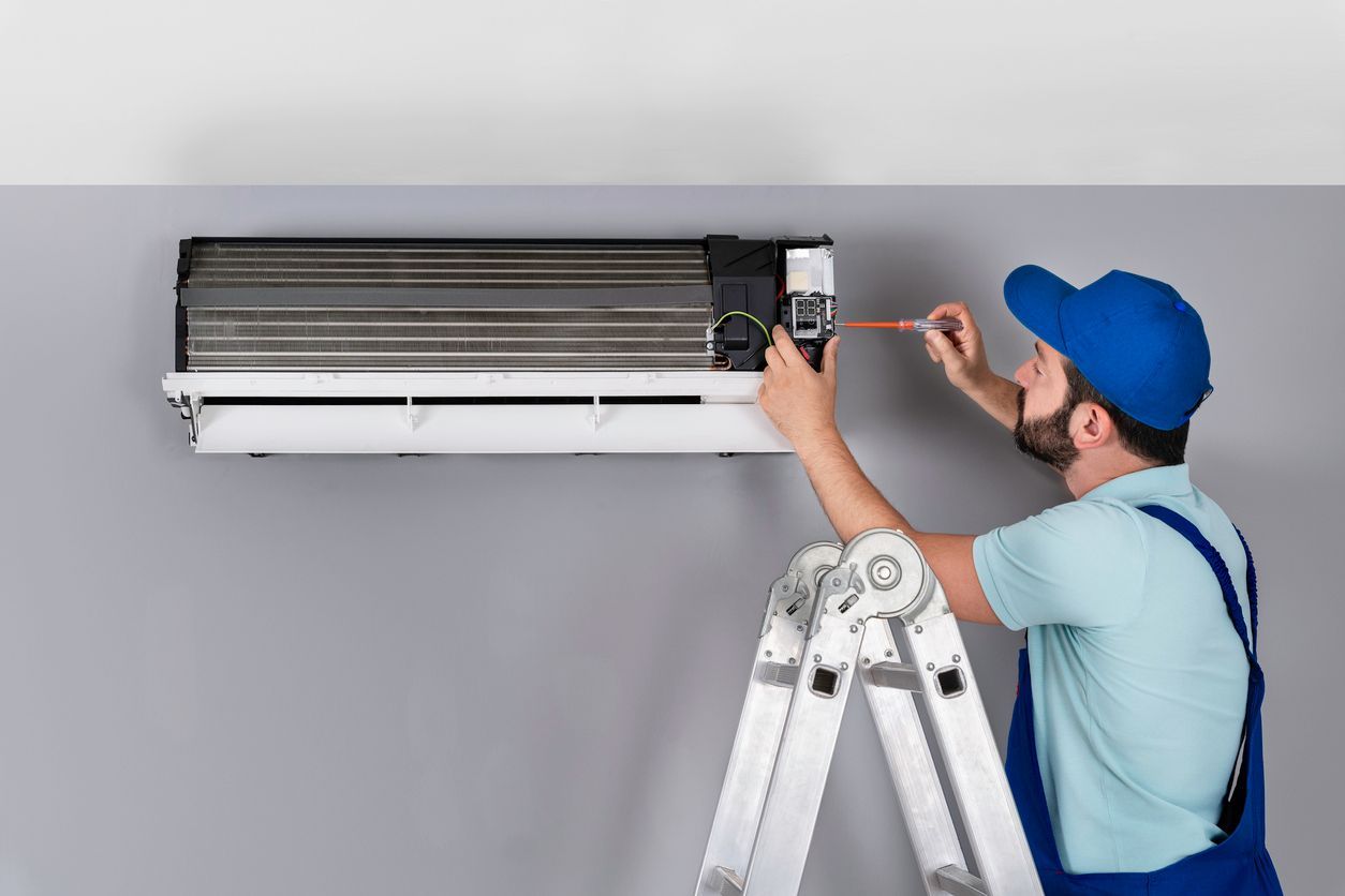 HVAC technician inspecting an air conditioner coil for leaks.