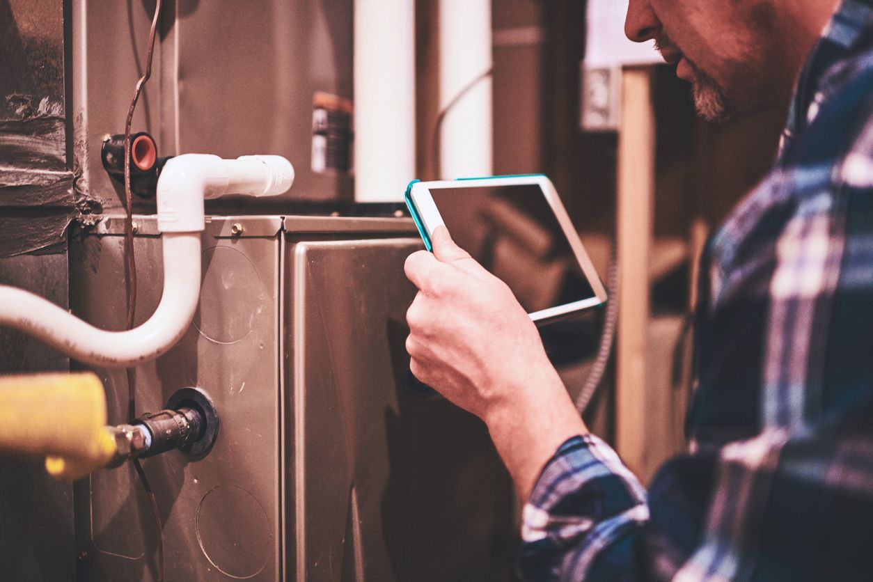 Technician reviewing system to recommend a gas or electric furnace in a Staten Island home.