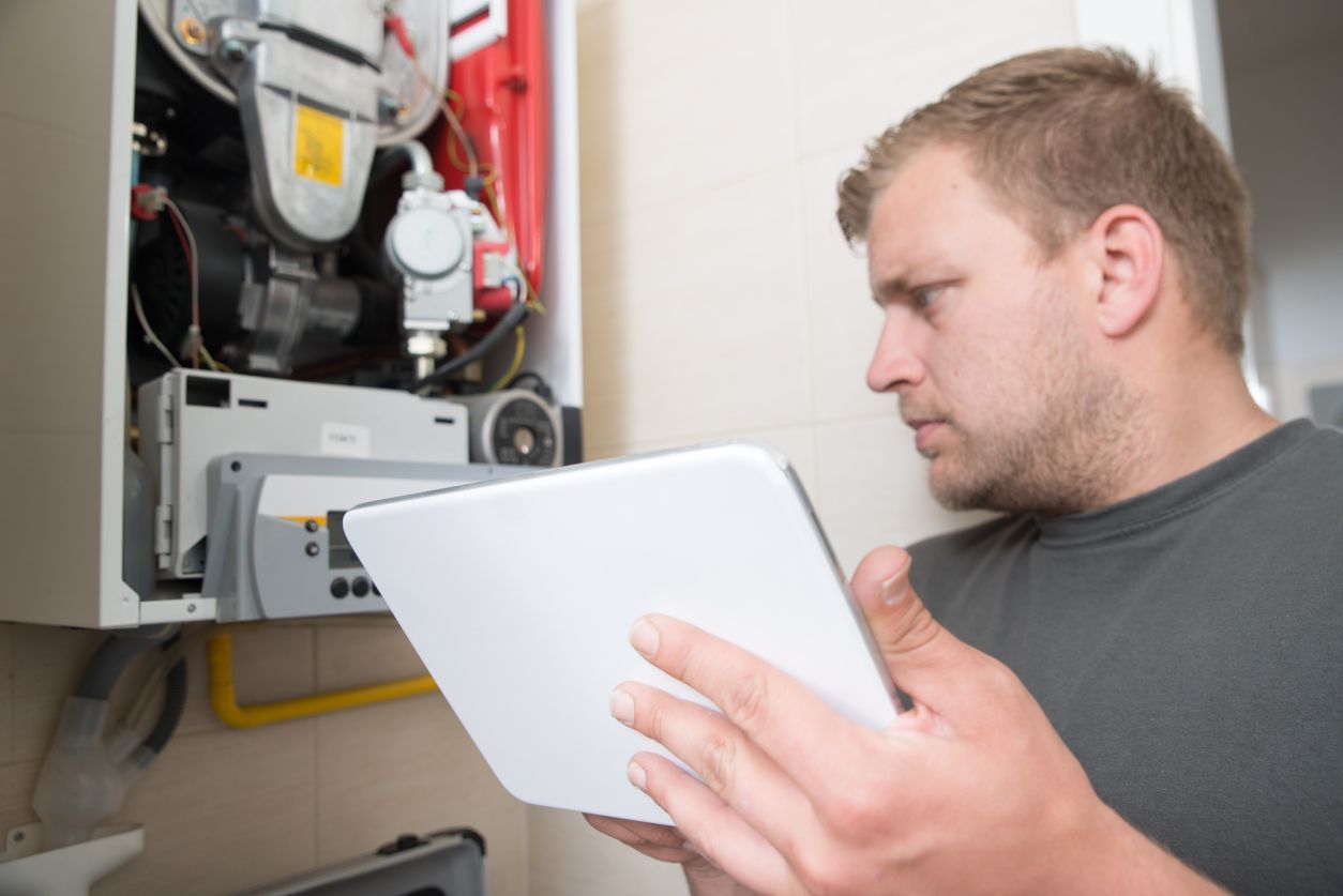 HVAC technician inspecting gas furnace and replacing the air filter in Brooklyn home during winter.