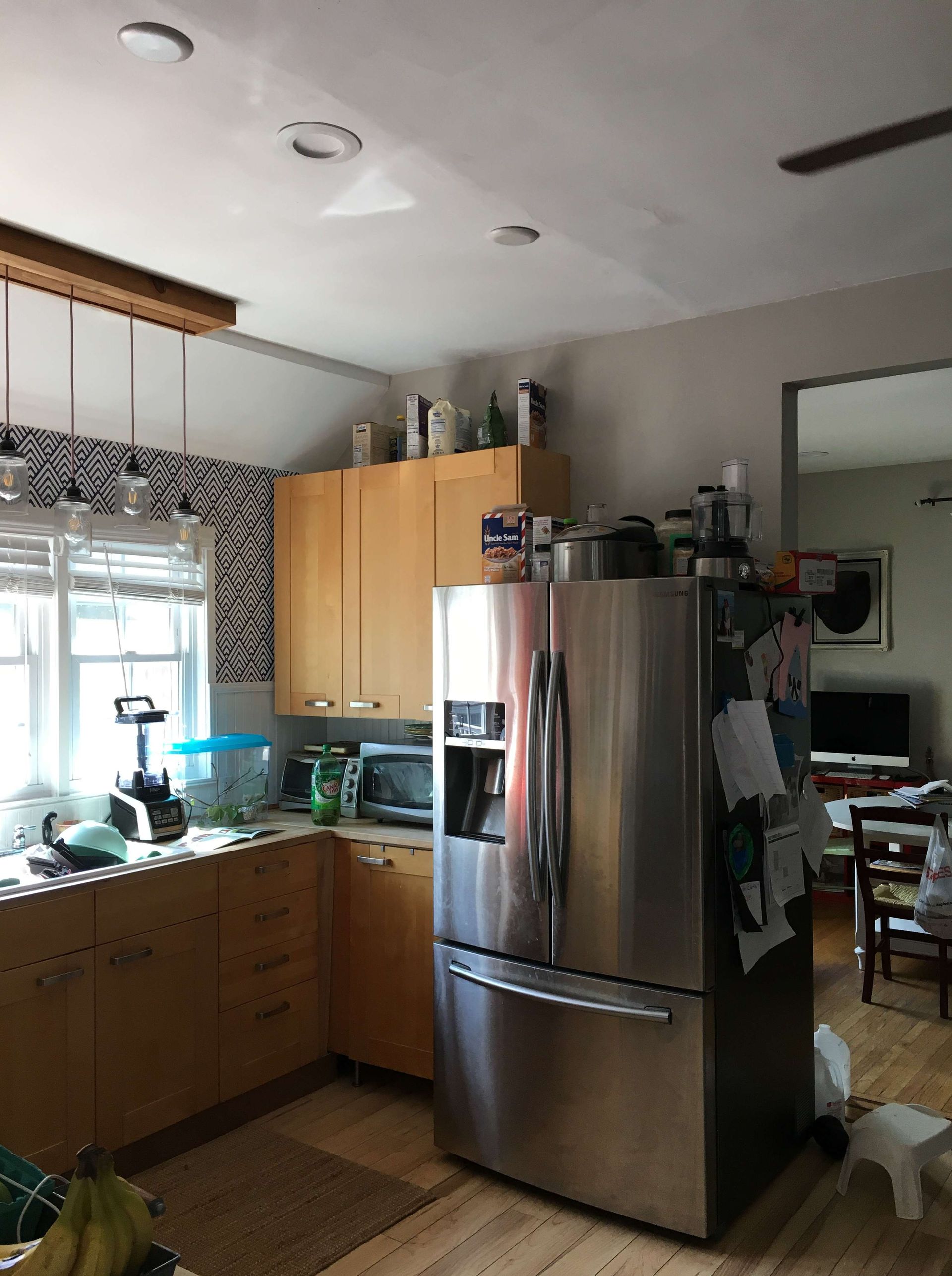 A kitchen with a stainless steel refrigerator and wooden cabinets.