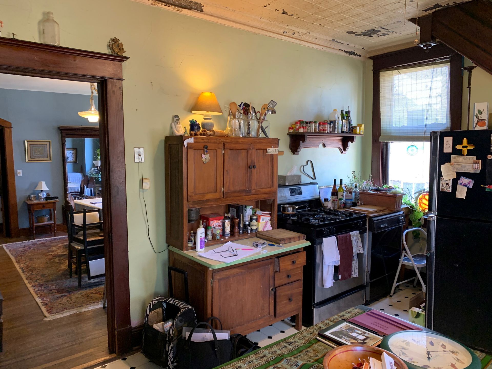 A kitchen with a stove , refrigerator and cabinets, before renovation.