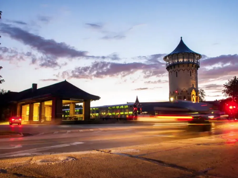 Evening view of the Evanston Water Tower and surrounding buildings with car lights blurring across a street.