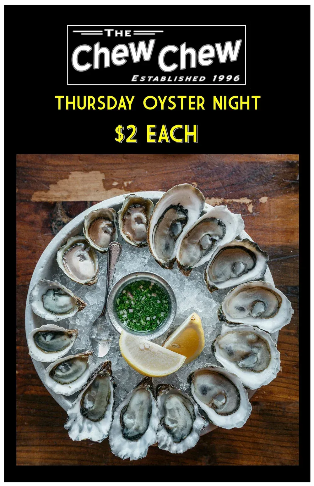 Oyster night promotion: Platter of oysters on ice with lemon wedge and sauce. 