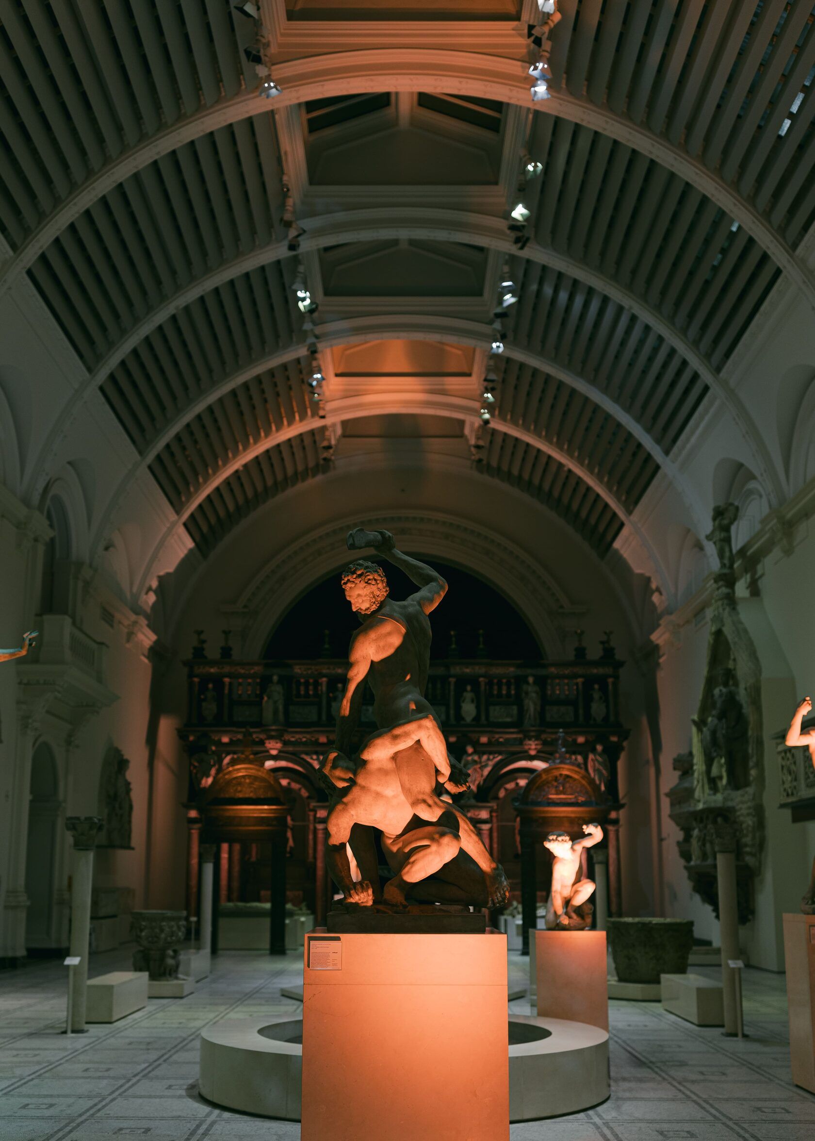 Sculpture of a man on a bull in a grand hall with arched ceiling. Warm lighting.