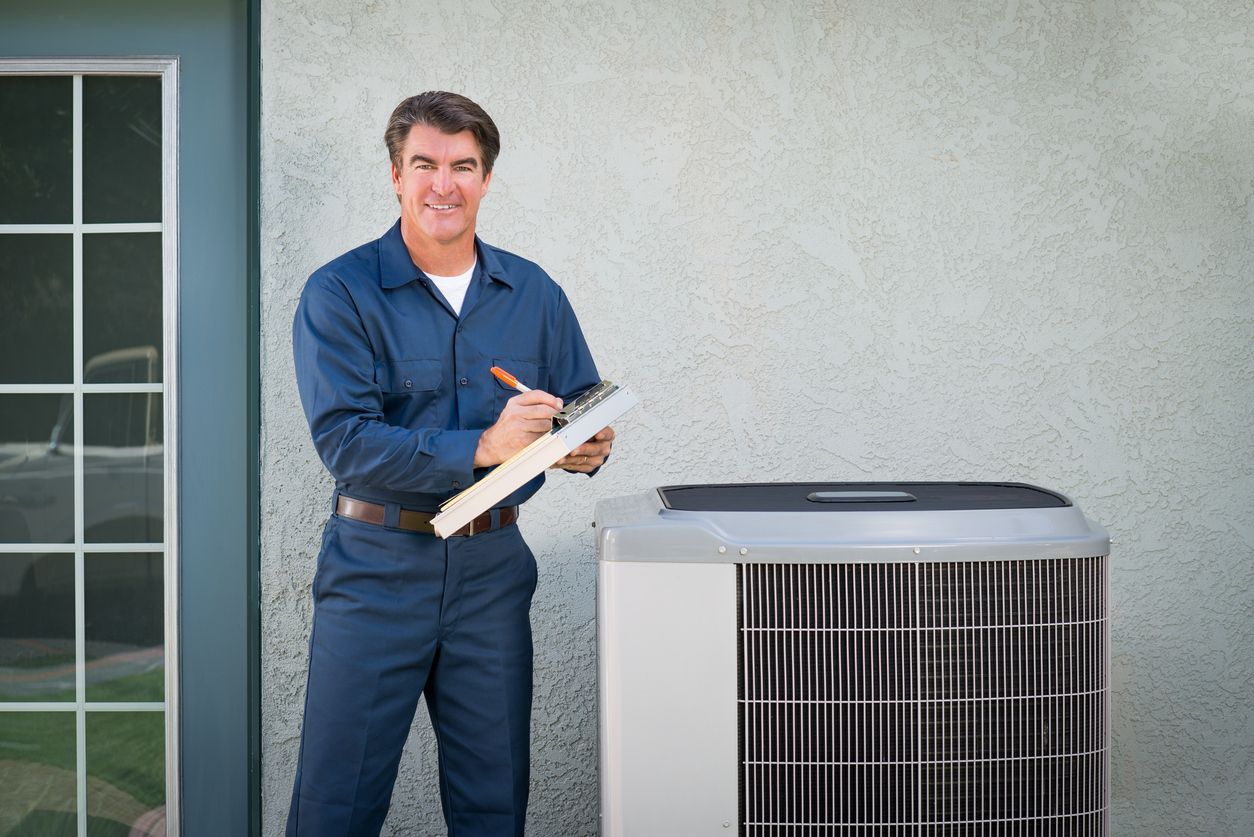 Airmax technician in blue uniform smiling, holding a clipboard, next to an outdoor air conditioner.