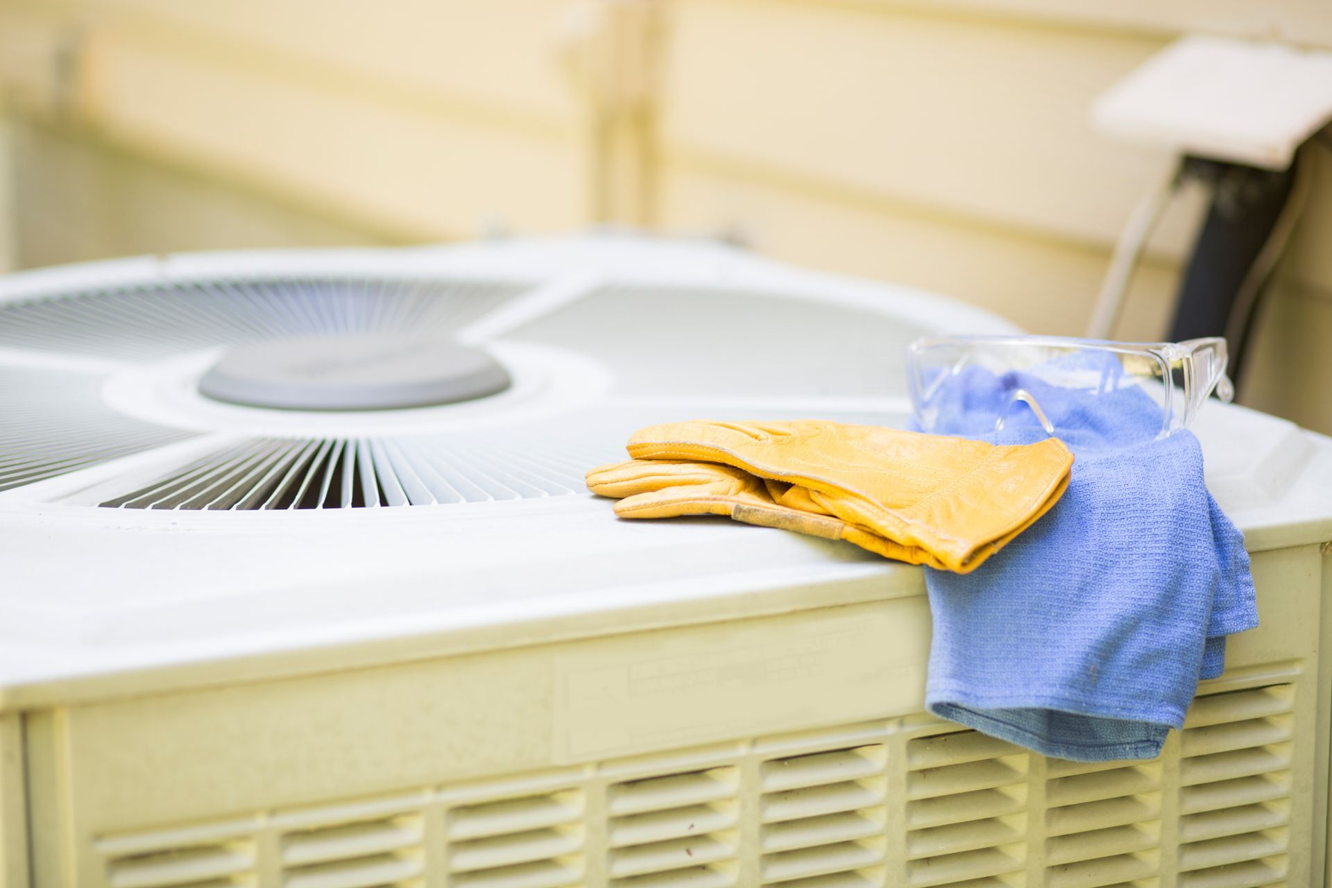 HVAC technician inspecting an outdoor AC unit during a hot summer day in a North Texas neighborhood.