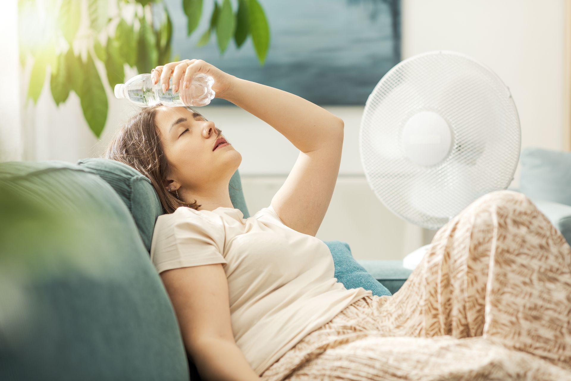 Woman struggling with extreme indoor heat during Texas summer heat wave in Collin County home.