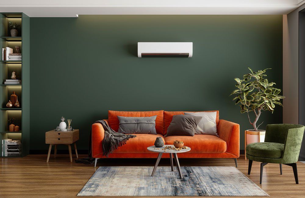 Living room with orange couch, green wall, and bookshelf.