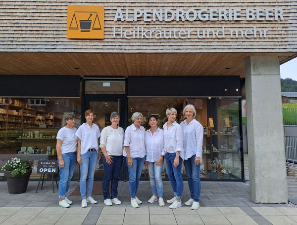 A group of women standing in front of a store called alpendrogerie beer