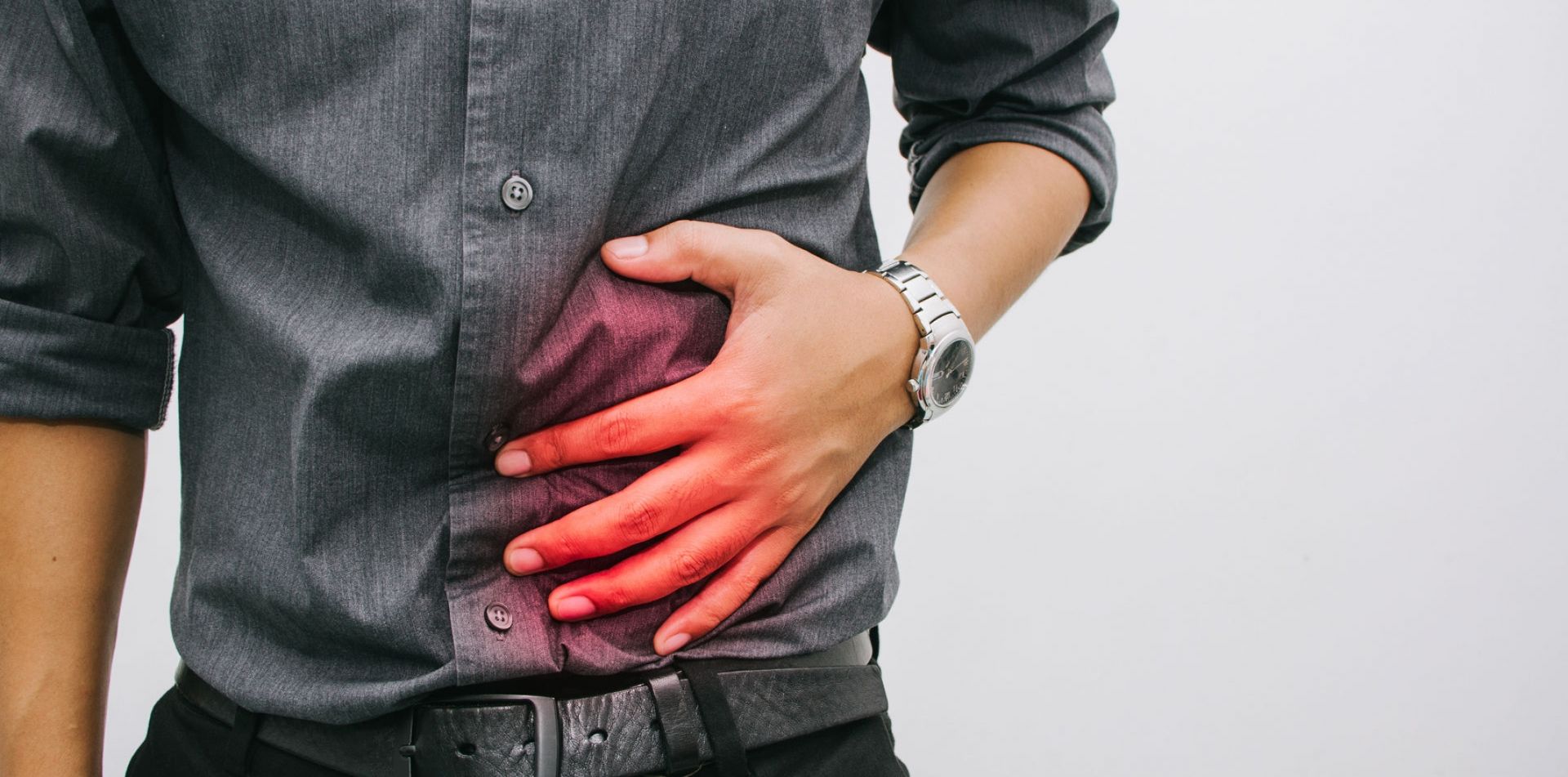 A man is holding his stomach in pain.