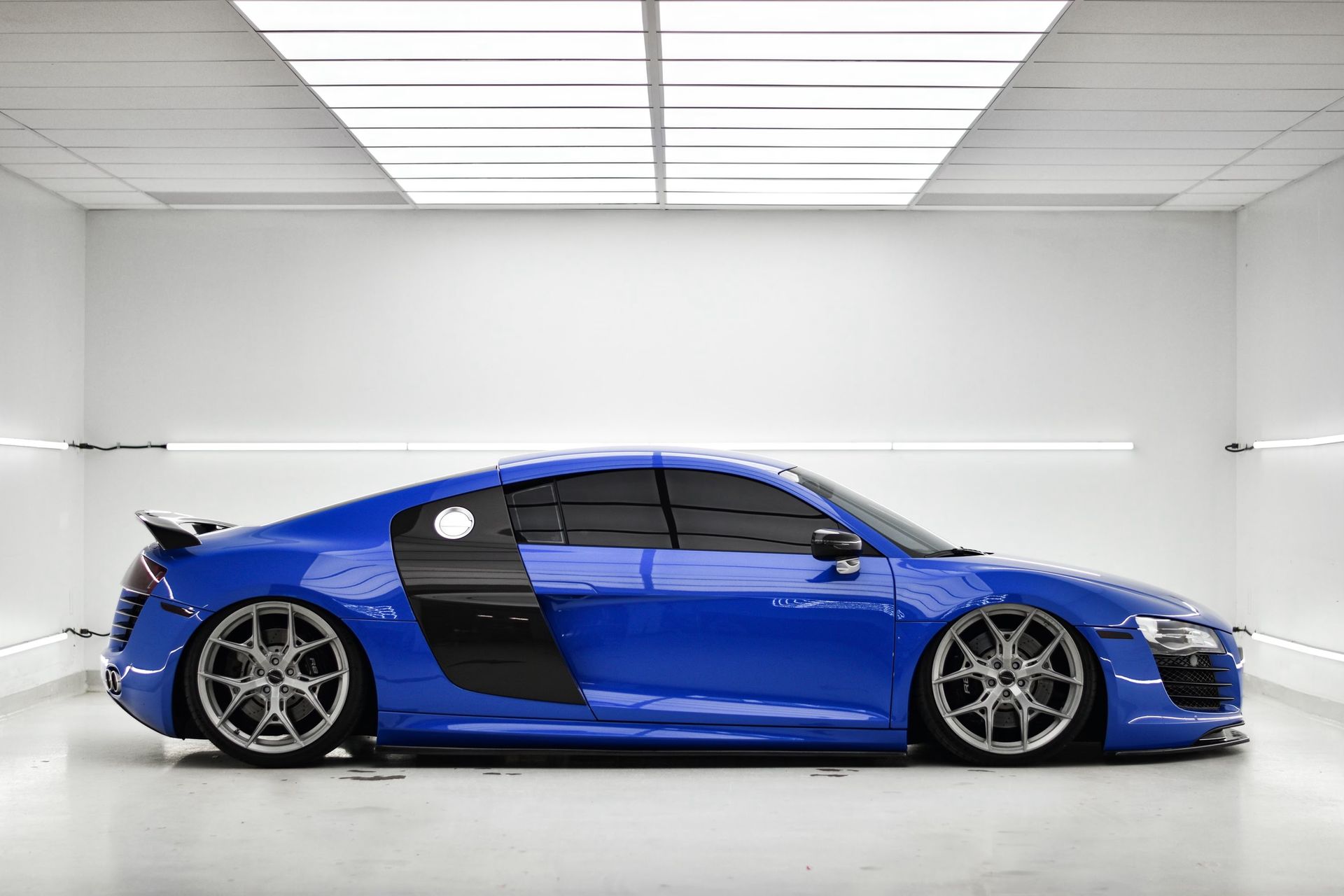 A blue audi r8 is parked in a garage.