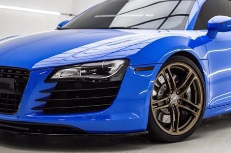 A blue audi r8 is parked in a garage.
