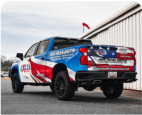 A red , white and blue truck is parked in front of a building.