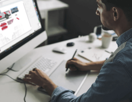 A man is sitting at a desk working on a computer