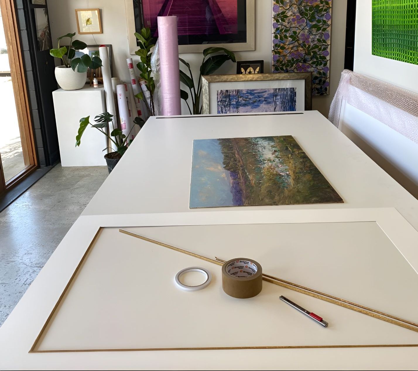 A table with a painting on it and a roll of tape — The Picture Framer In Parramatta Park, QLD