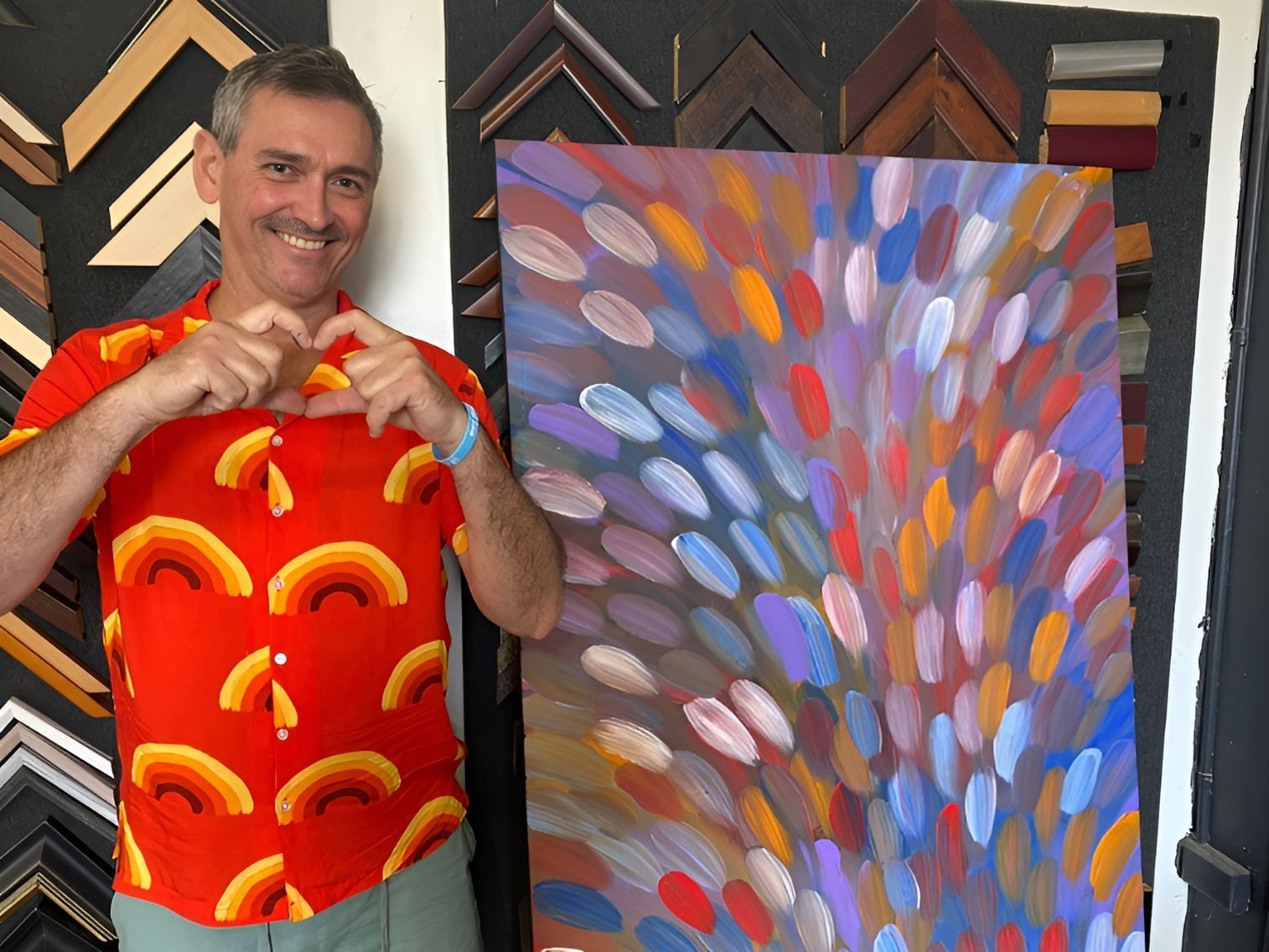 A Man in A Red Shirt is Standing in Front of A Painting - The Picture Framer In Parramatta Park, QLD