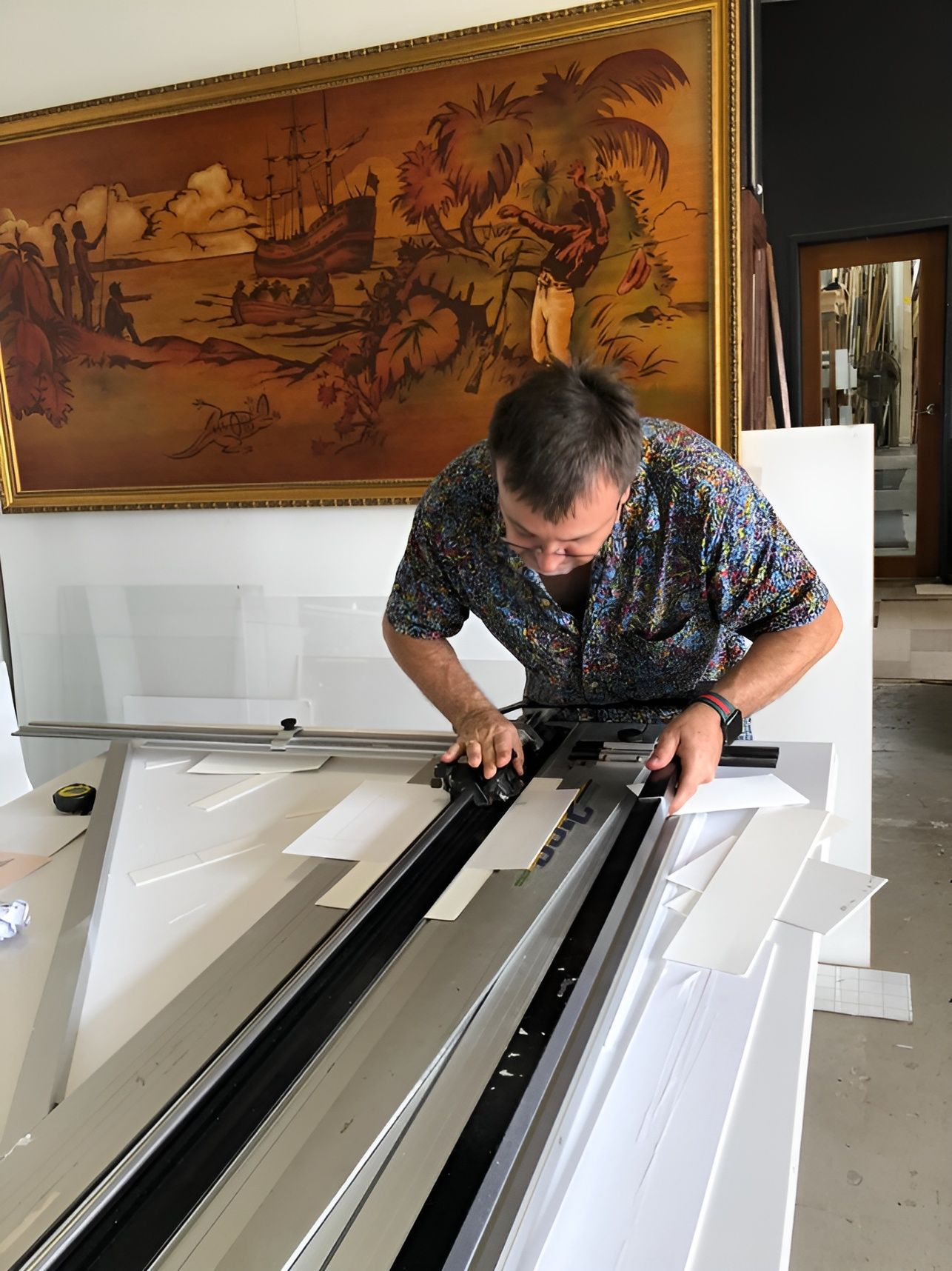 A Man Is Smiling In Front Of A Wall Of Picture Frames — The Picture Framer In Parramatta Park, QLD