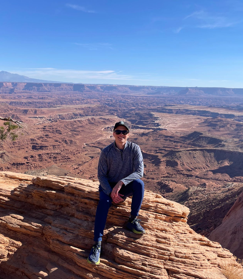 A picture of me posing in Canyonlands National Park right next to Mesa Arch.