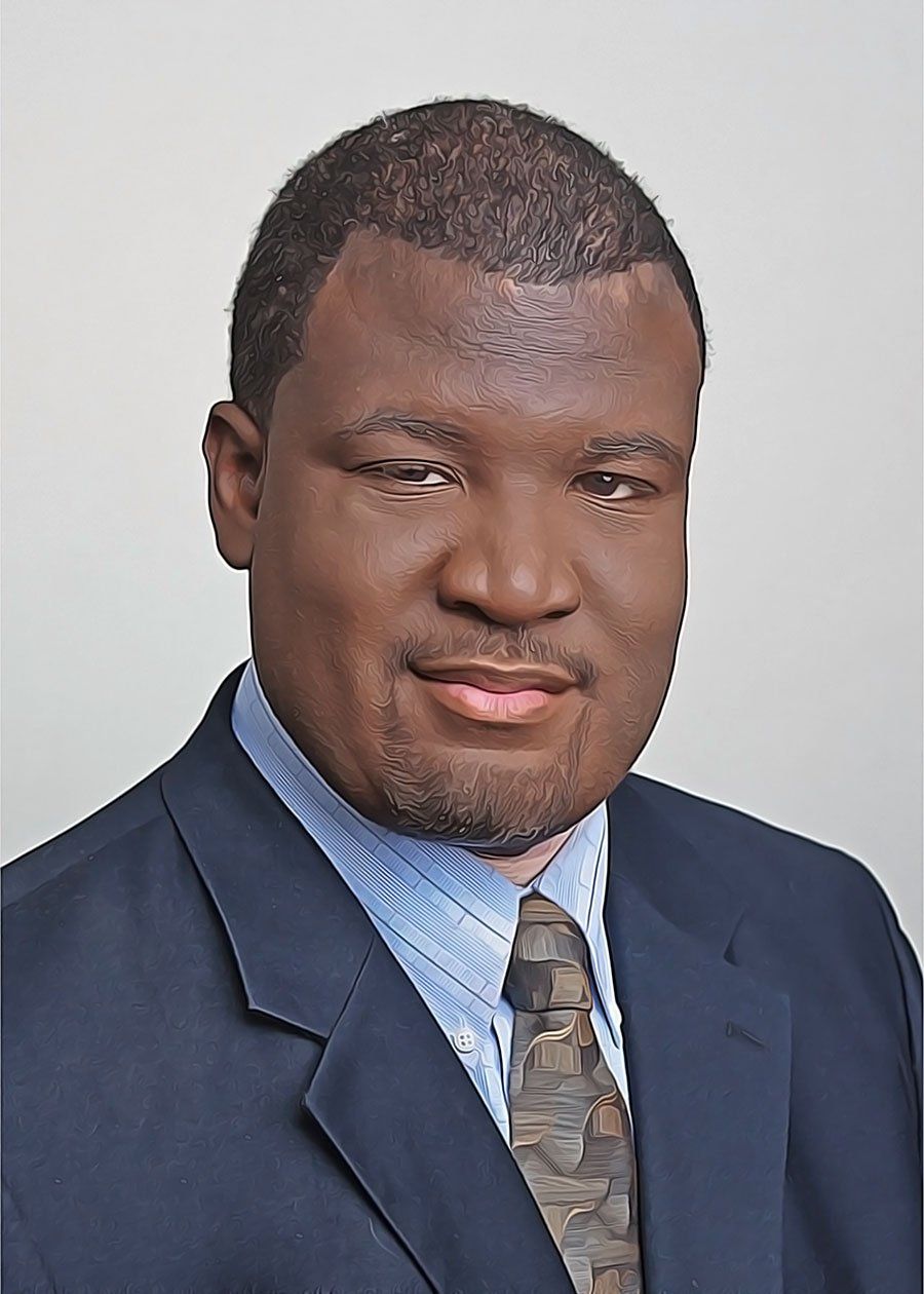 A man in a suit and tie is smiling for the camera