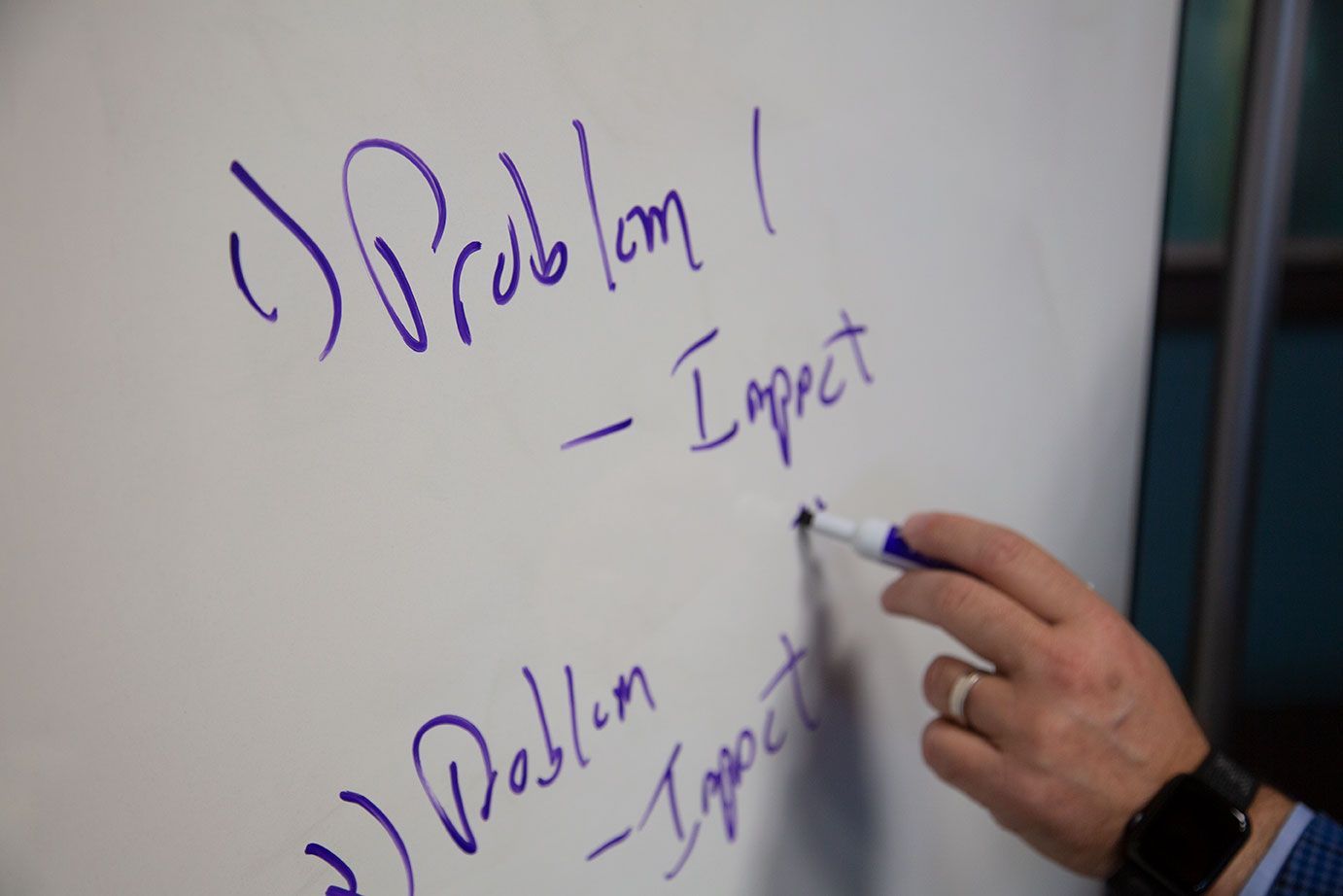 a person writes the word problem on a white board