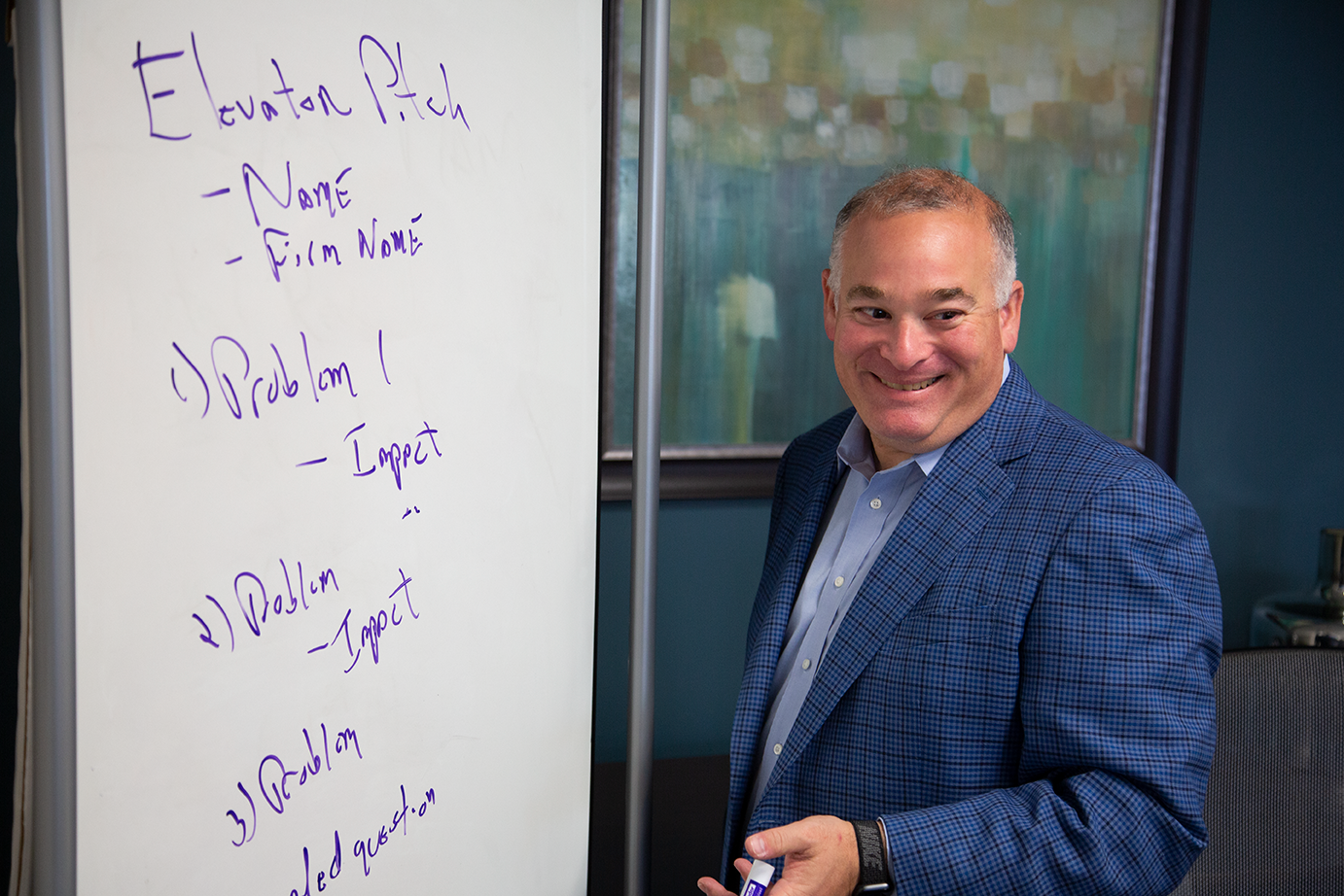 a man stands in front of a white board that says elevation pitch
