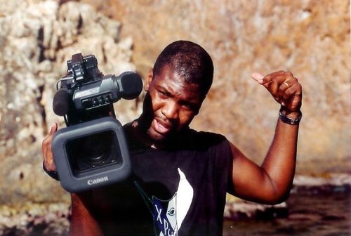a man is holding a canon camera in his hand