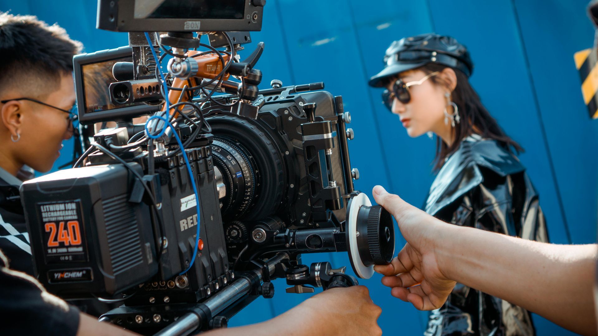 A man and a woman are standing in front of a camera.