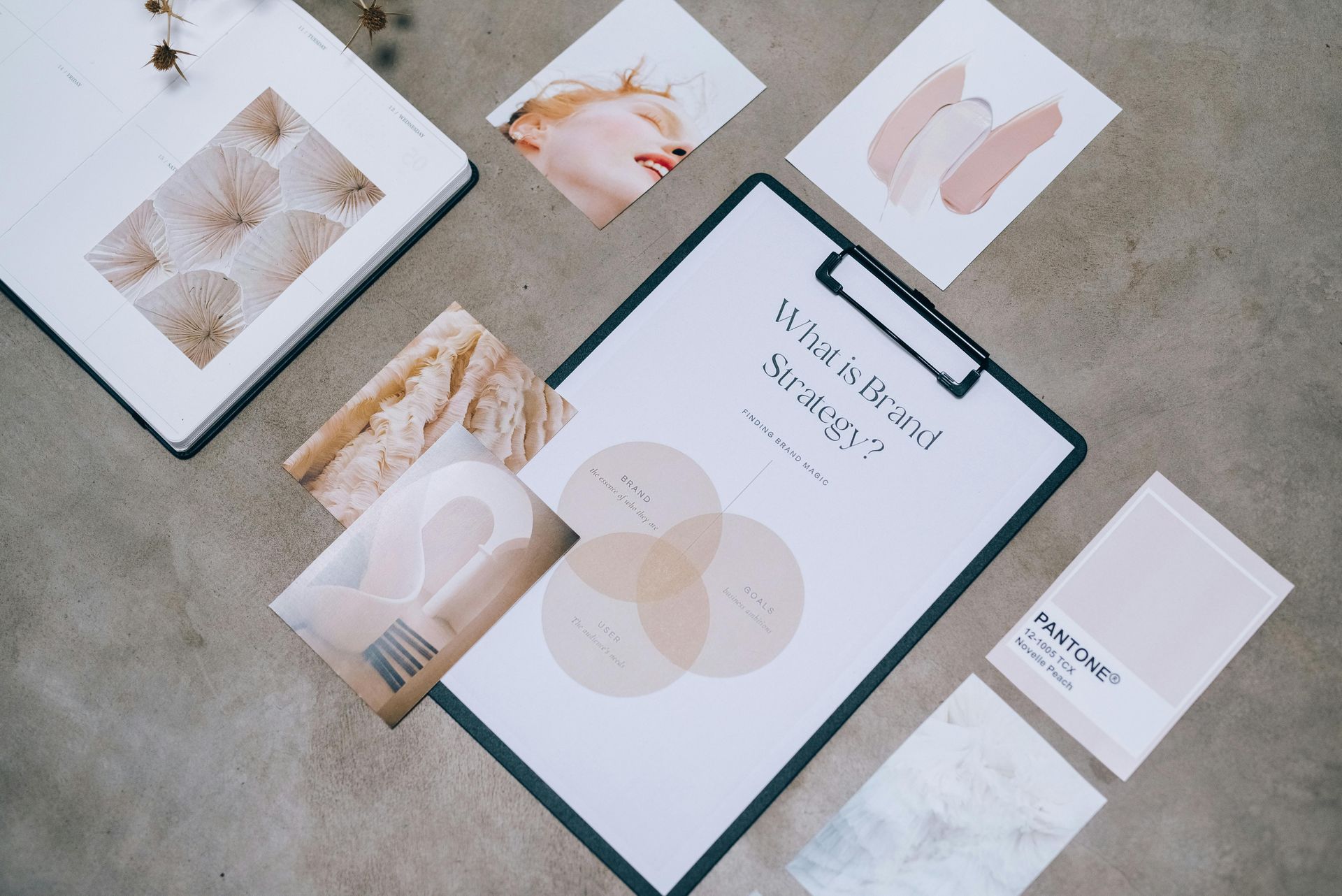 A clipboard is sitting on top of a table next to a book and cards.