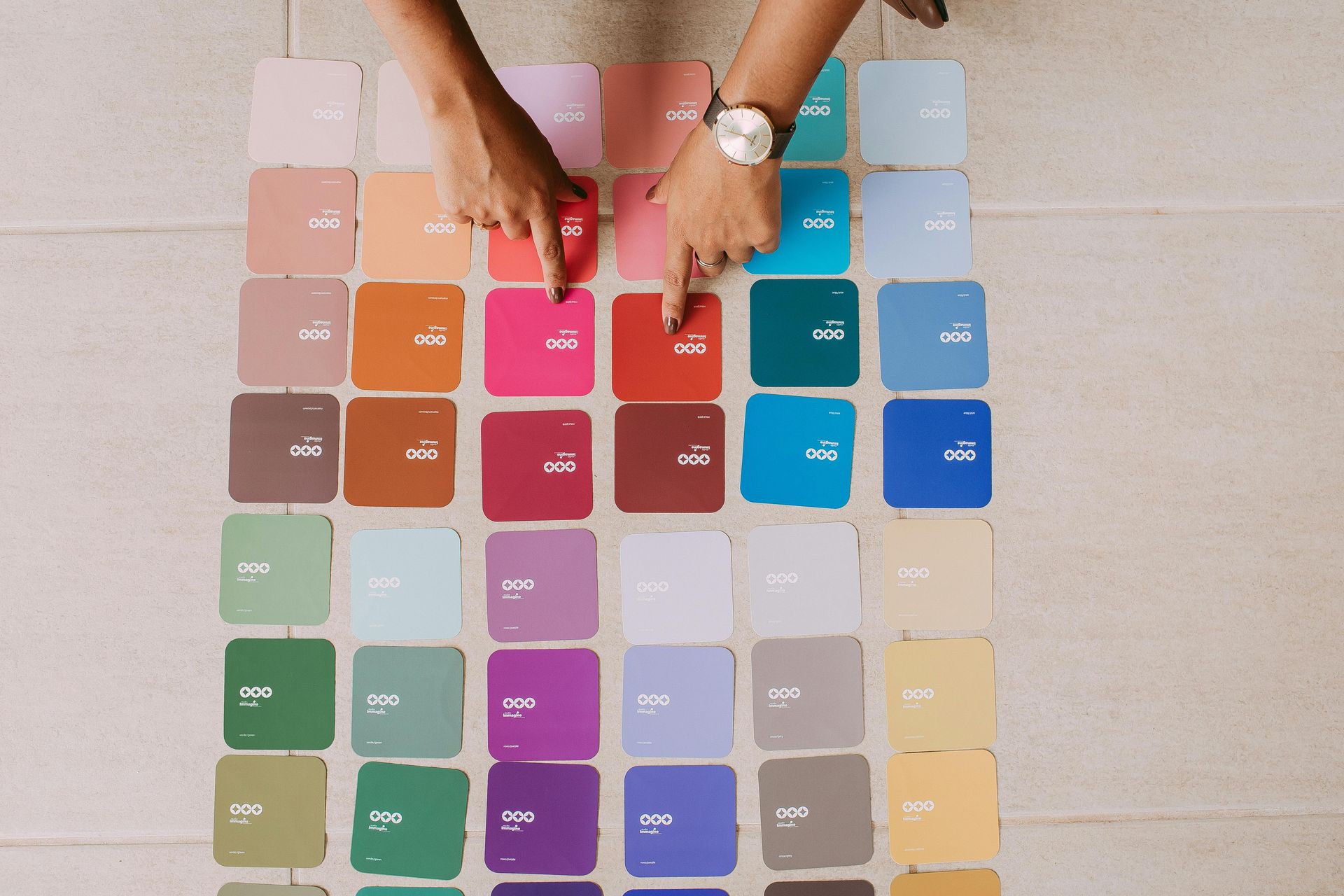 A person is picking a color from a palette of paint samples.