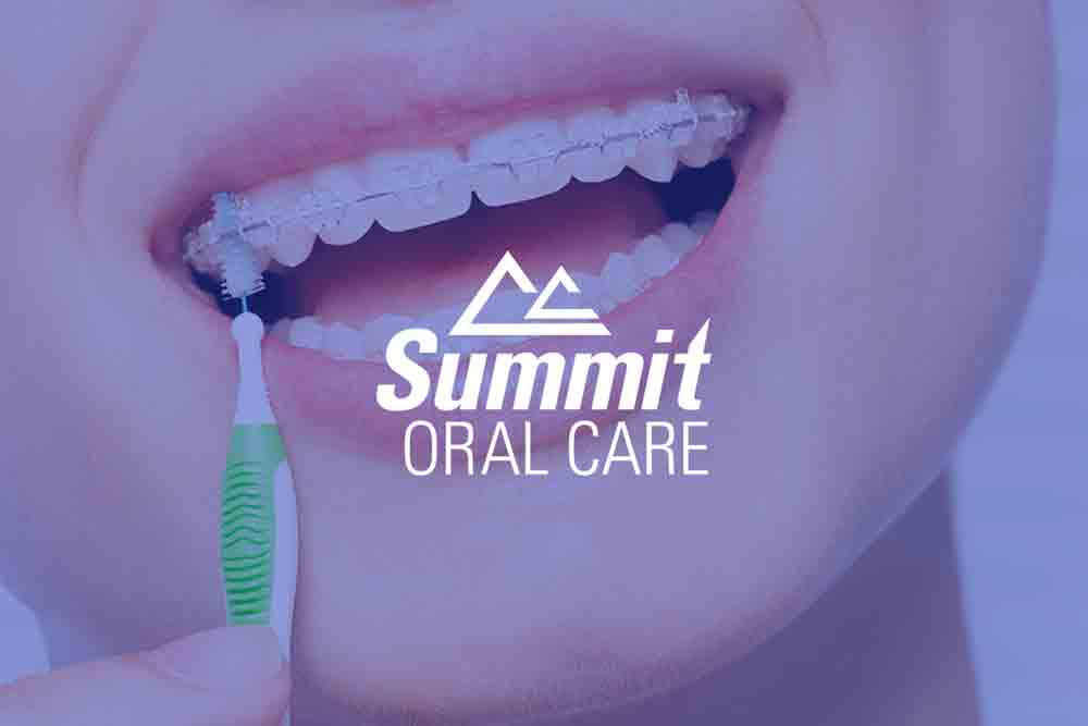 a woman with braces is brushing her teeth with an interdental brush .